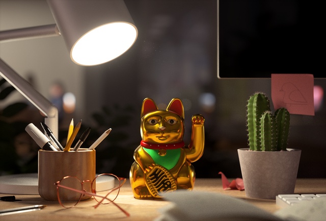 A gold Lucky Cat sitting on a desk
